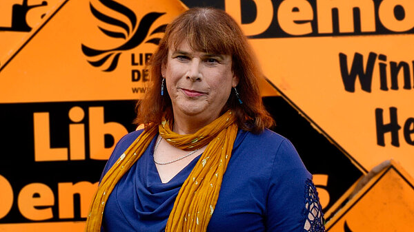 Helen Belcher stood in front of giant correx diamonds that say "Liberal Democrats"